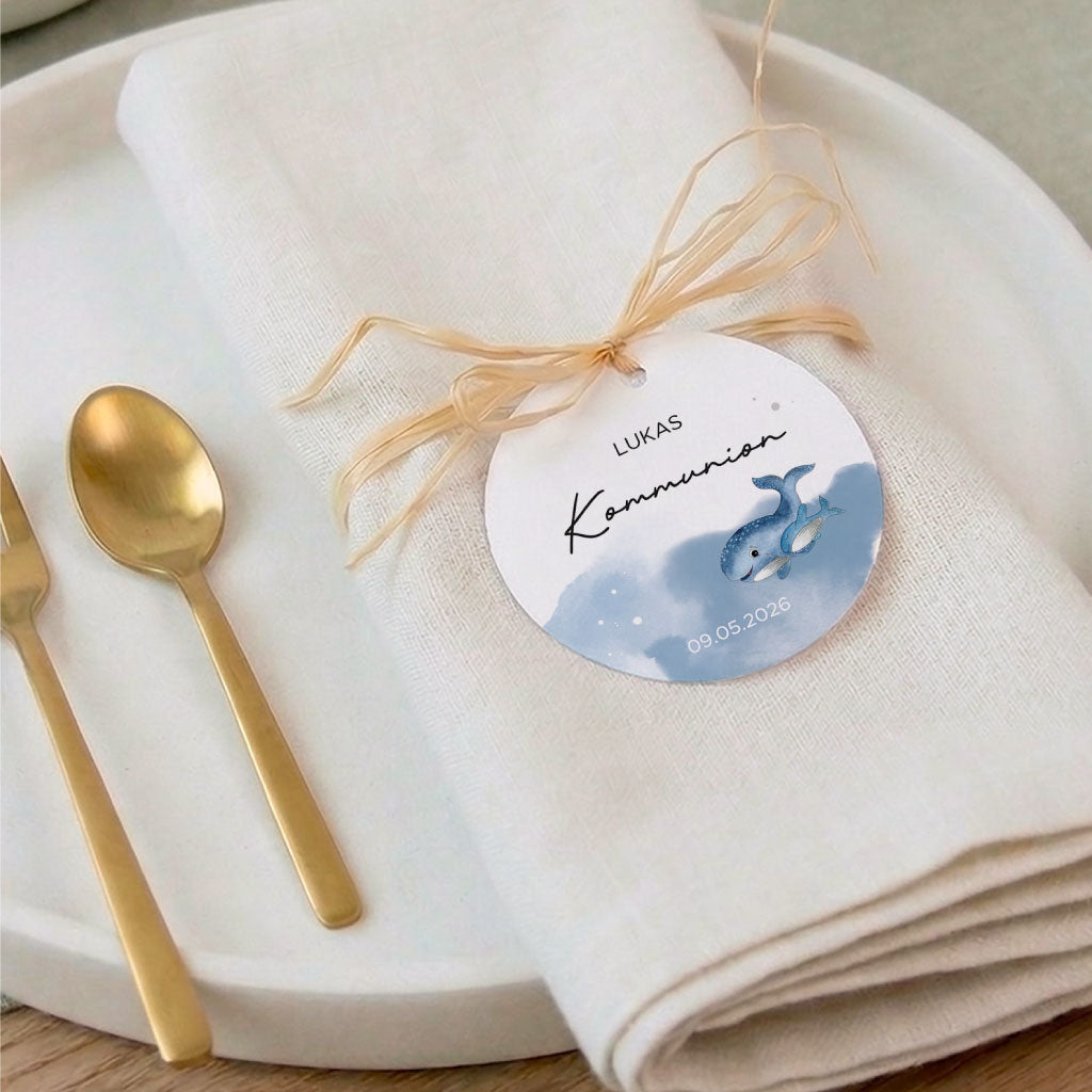 Festliche Tischdeko mit goldenem Besteck und einem personalisierten Anhänger samt Wal Aquarell Motiv zur Kommunion.