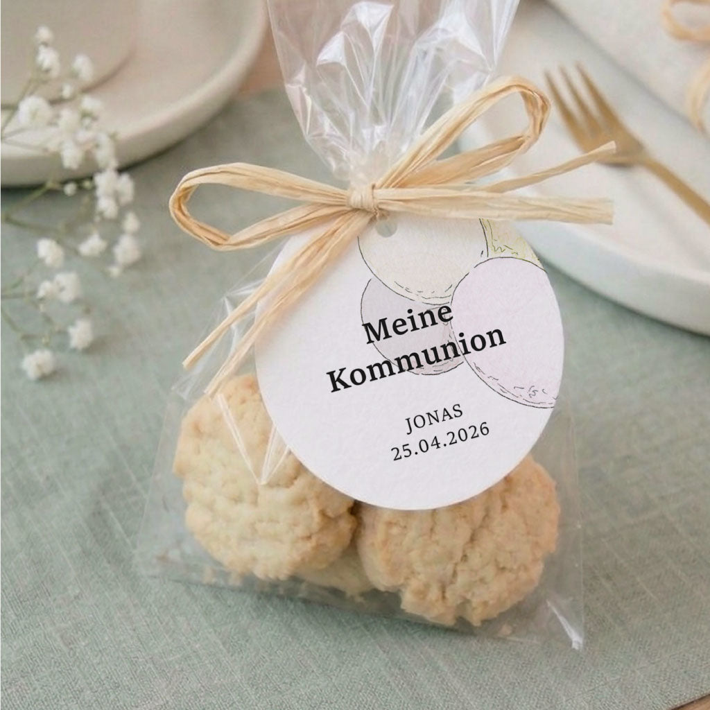 Runder Anhänger für Gastgeschenke zur Kommunion mit Luftballon Aquarell Motiv an Keksverpackung.