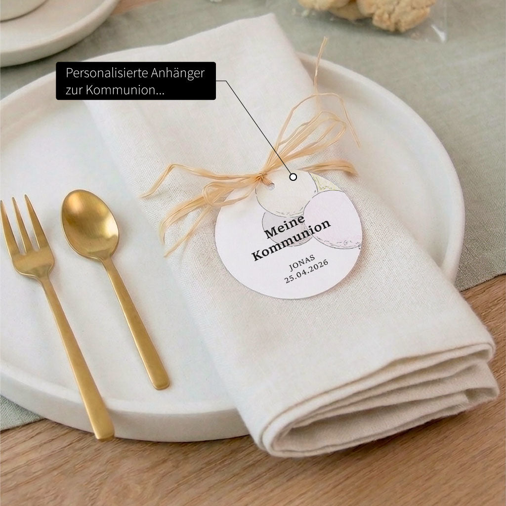 Personalisierter Anhänger zur Kommunion als stilvolle Tischdeko an einer weißen Serviette gebunden.