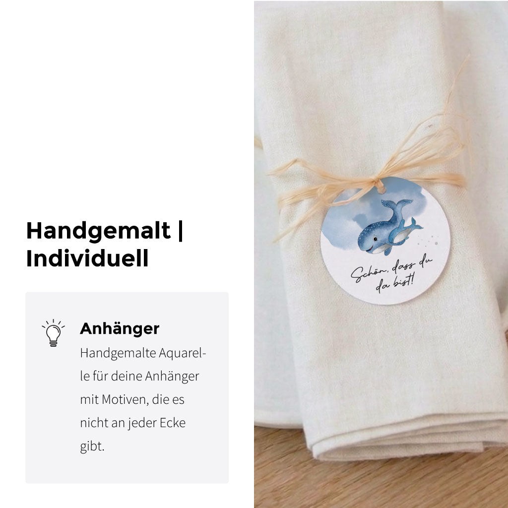 Tischdeko für die Kommunion mit einer Serviette und einem Anhänger der ein handgemaltes Wal Aquarell Motiv zeigt.