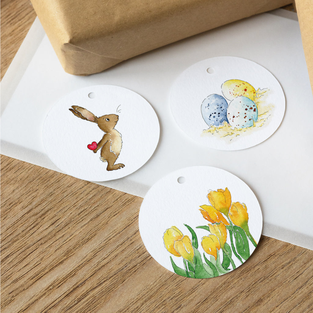 Runde Anhänger zu Ostern mit Aquarellen von Osterhase, Ostereiern und gelben Tulpen – ideal als Dekoration oder zum Ostergeschenke verpacken.