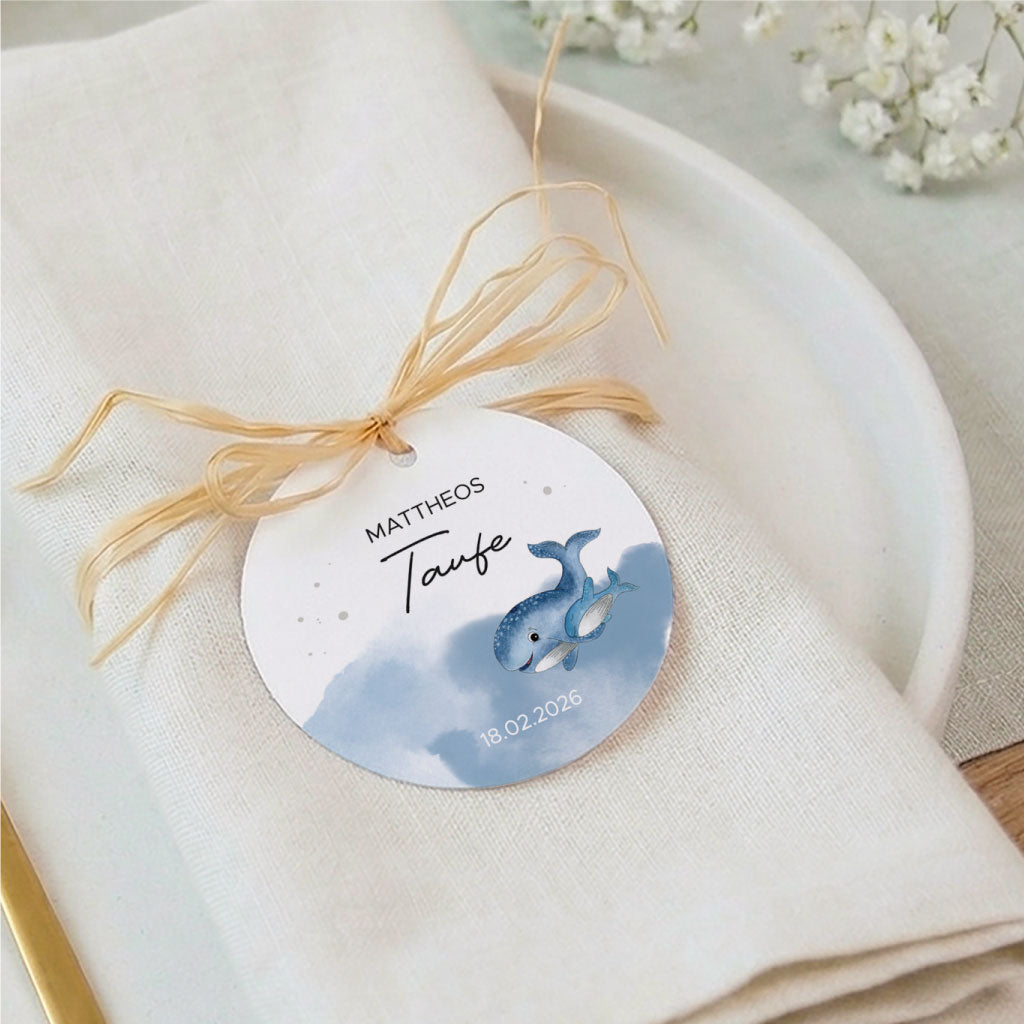 Nahaufnahme der edlen Tischdeko zur Tauffeier mit einem personalisierten Anhänger auf der Serviette.