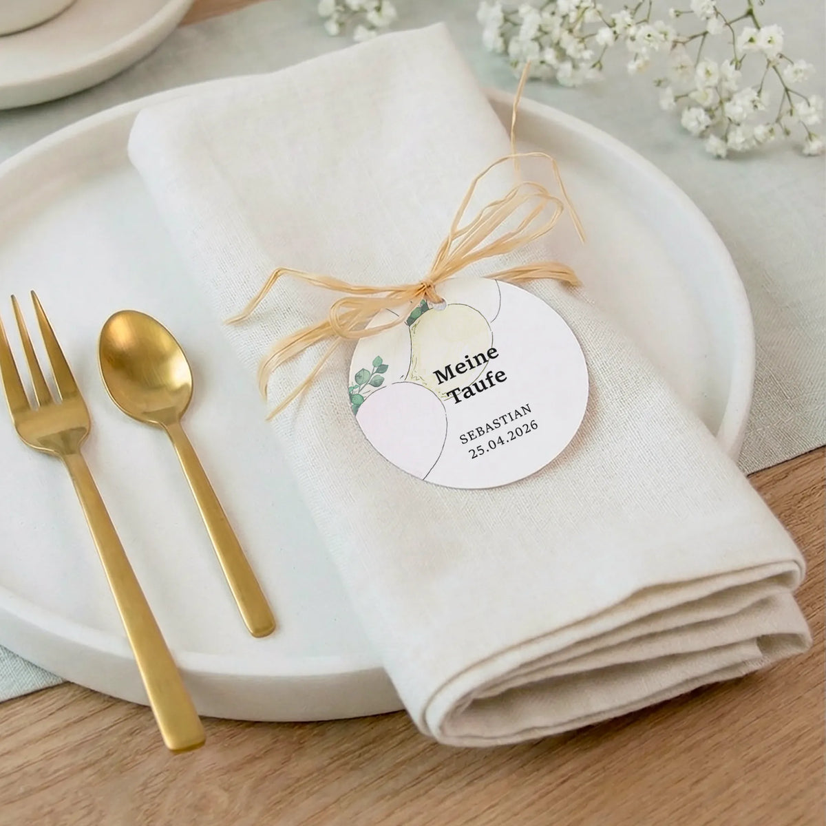 Personalisierter Taufe Anhänger mit Aquarell Motiv Luftballons auf gefalteter Serviette mit Goldbesteck als Tischdeko