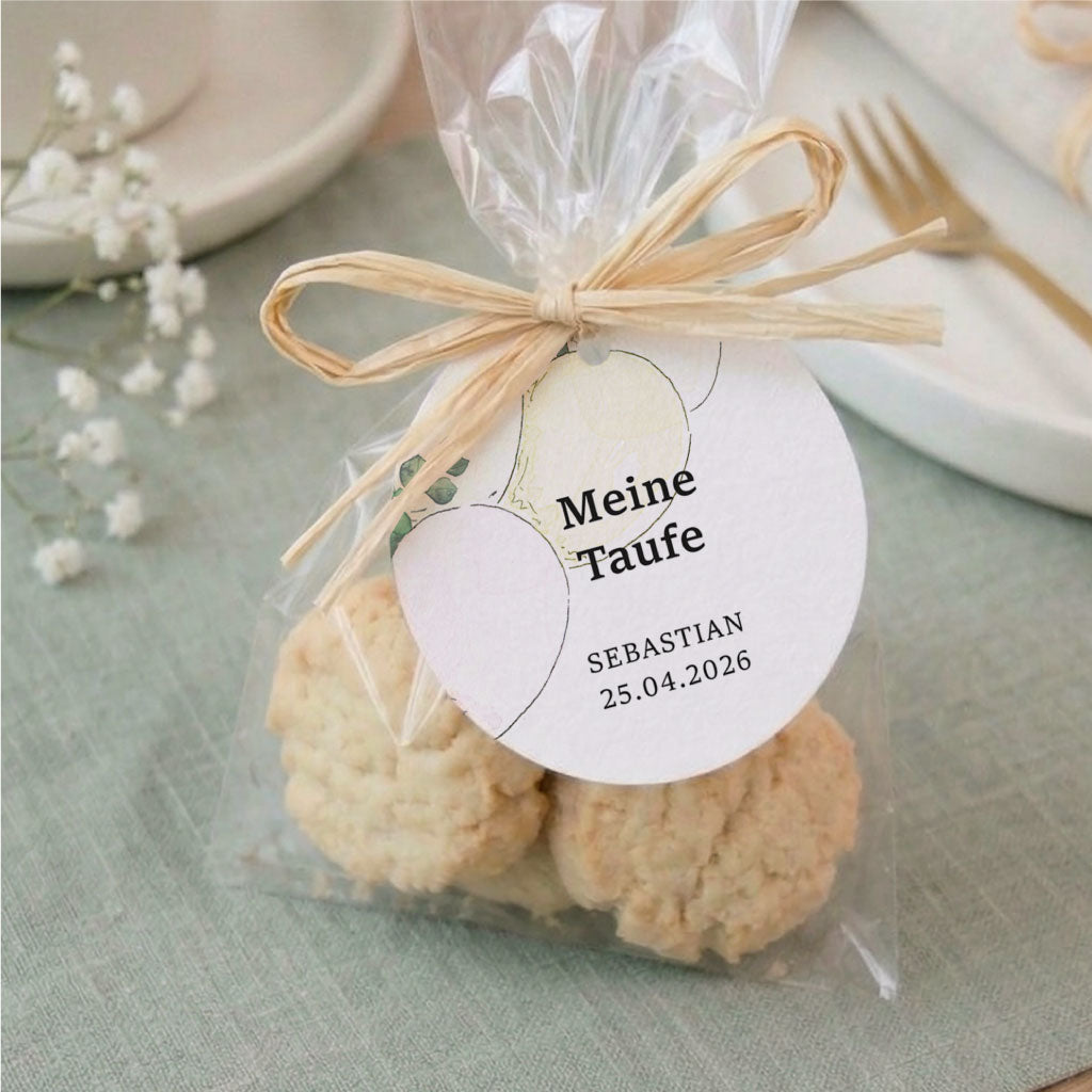 Runder personalisierter Anhänger zur Taufe mit Luftballon Aquarell Motiv an einem Gastgeschenk aus leckeren Keksen.