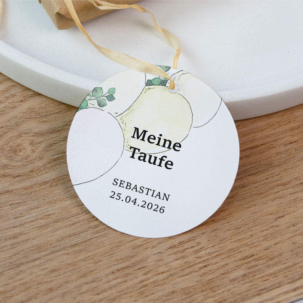 Ein liebevoll verpacktes Gastgeschenk aus Kraftpapier mit einem personalisierten Anhänger zur feierlichen Taufe.
