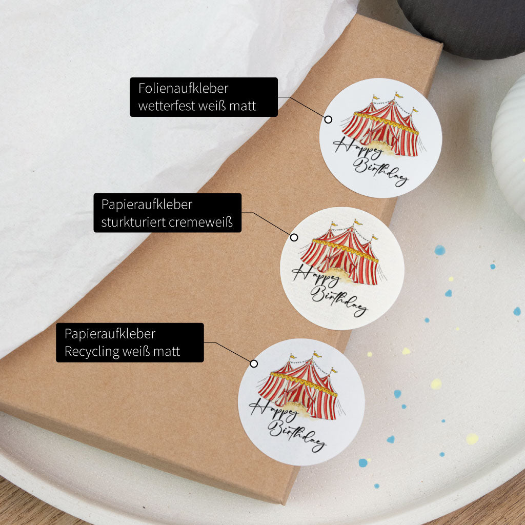 Vergleich der Materialien: Geburtstagsaufkleber-Sticker „Happy Birthday“ mit Zirkuszelt als Folienaufkleber und Papieraufkleber, für Geburtstagsgeschenk-Verpackung und Dekoration