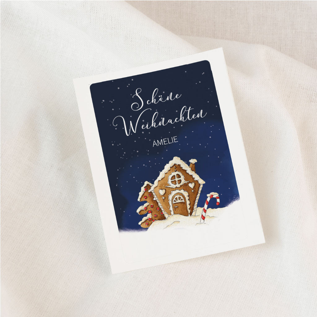 Personalisierbarer Weihnachtssticker für Grabkerzen mit handgemaltem Aquarell-Lebkuchenhaus vor dunklem Nachthimmel und Schneelandschaft.