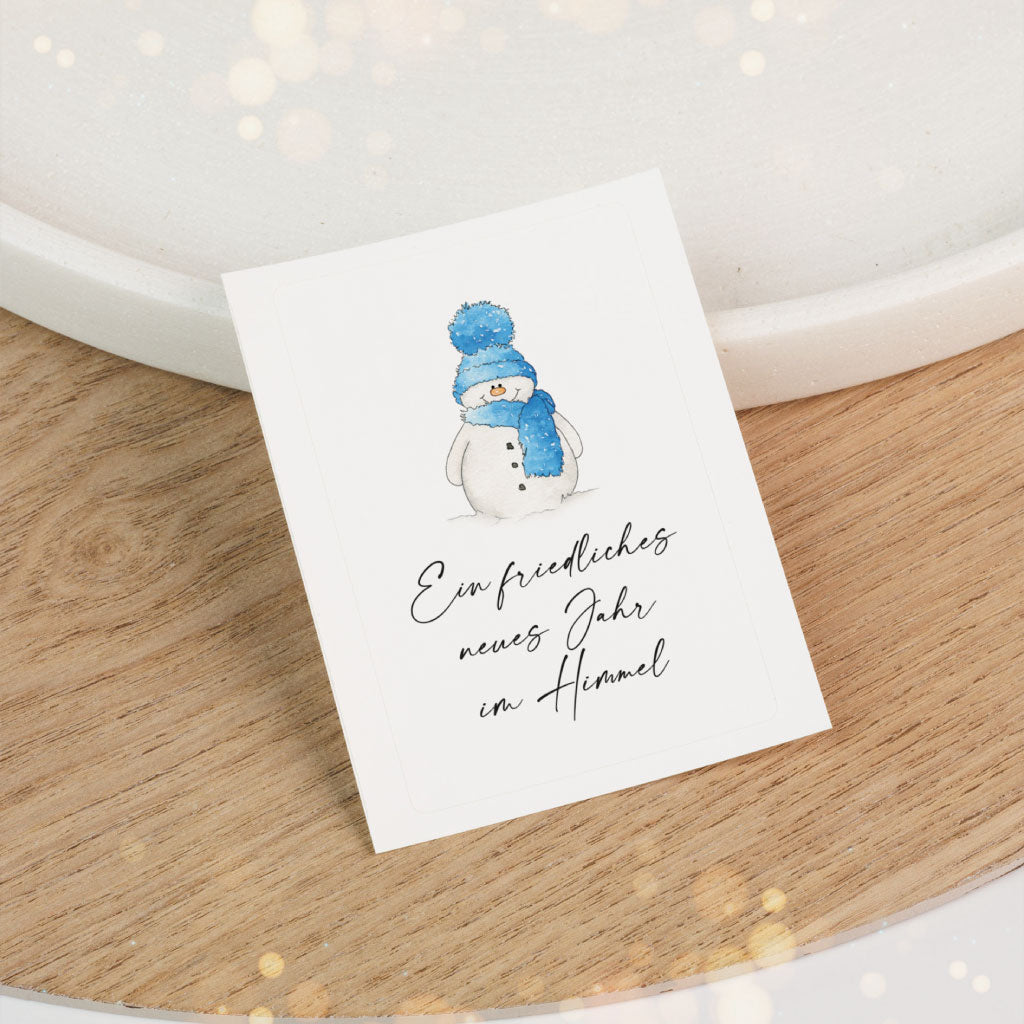 Sticker mit winterlichem Schneemann und dem Text „Ein friedliches neues Jahr im Himmel“ – ideal für eine Grabkerze zu Silvester.