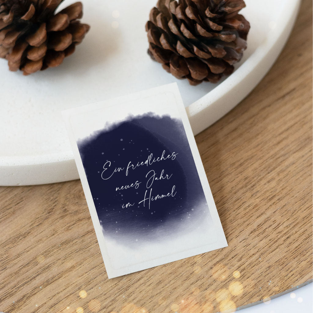 Aufkleber mit dunklem Aquarellhimmel und der Aufschrift „Ein friedliches neues Jahr im Himmel“ – liebevoll gestalteter Sticker als Andenken für Silvester und den Jahreswechsel.