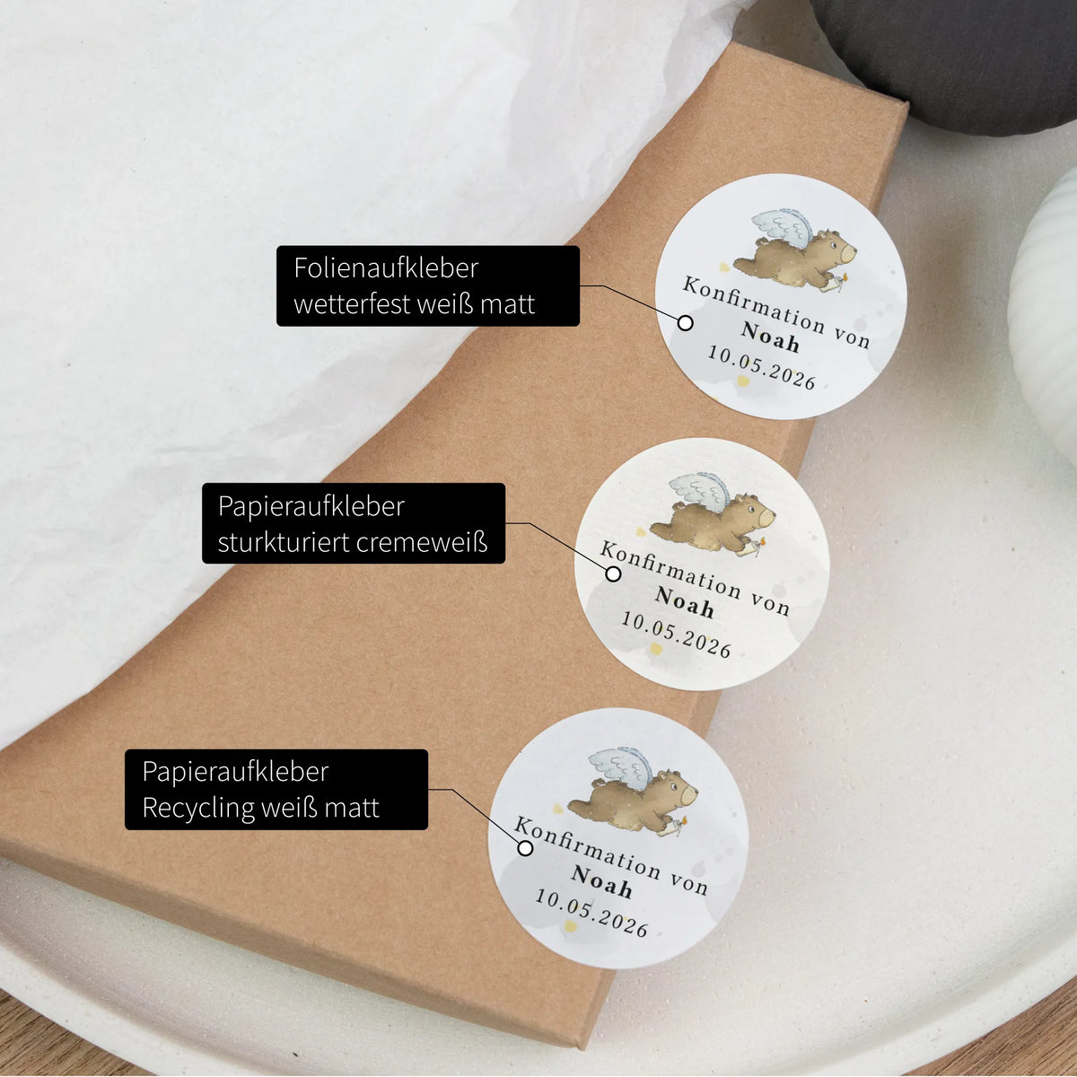 Drei Konfirmation-Aufkleber im Vergleich: Folienaufkleber, Papieraufkleber cremeweiß und Recycling, Aquarell Motiv Engelbär mit Name Noah und Datum