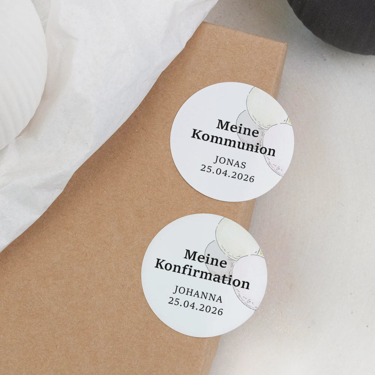 Zwei personalisierte runde Aufkleber zur Kommunion und Konfirmation mit Aquarell Motiv auf Kraftpapier-Geschenkbox, mit Name und Datum bedruckt