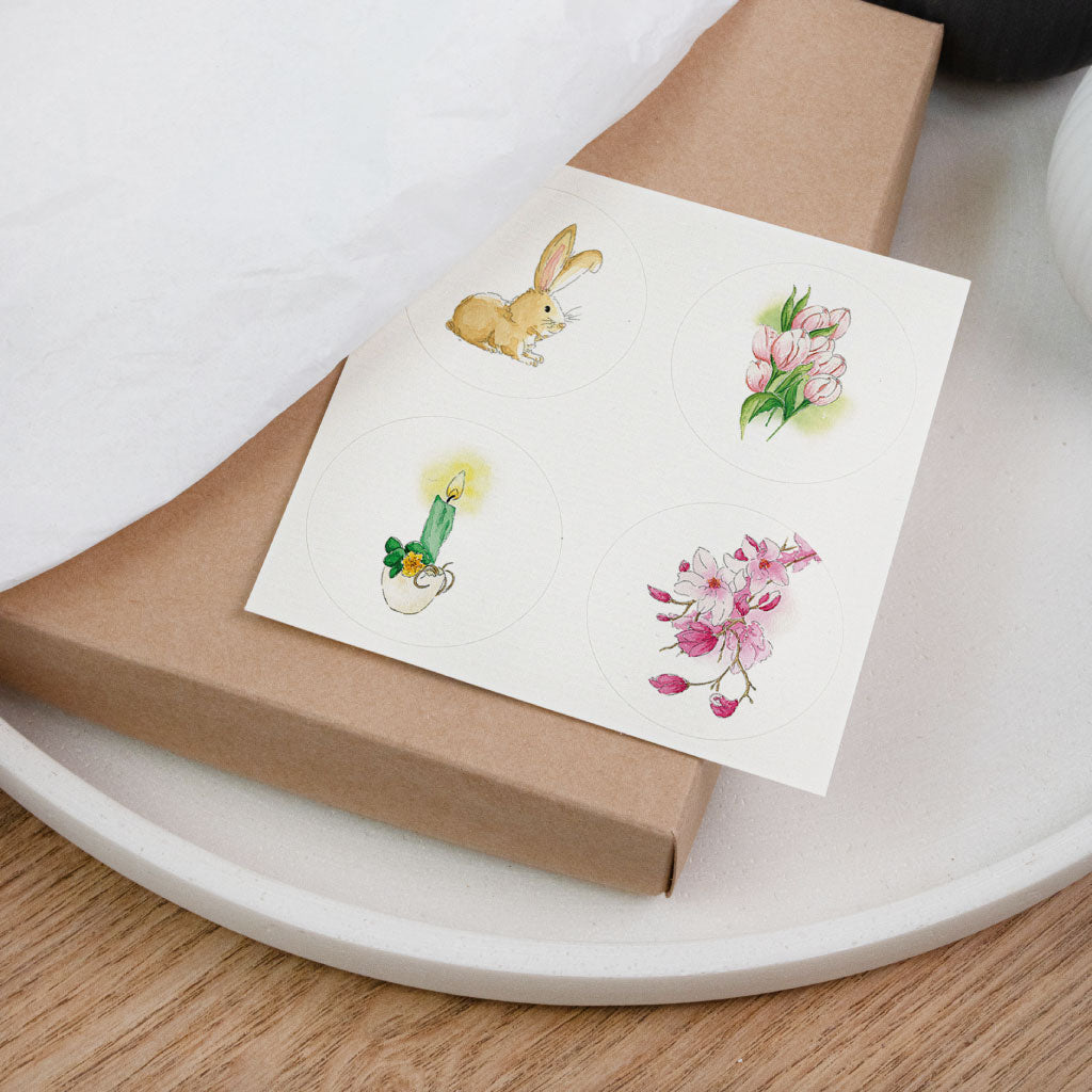 Aufkleberkarte mit 4 runden Stickern: Osterhase, Tulpen, Kerze und Blütenzweig – alles handgemalte Aquarelle im Set.