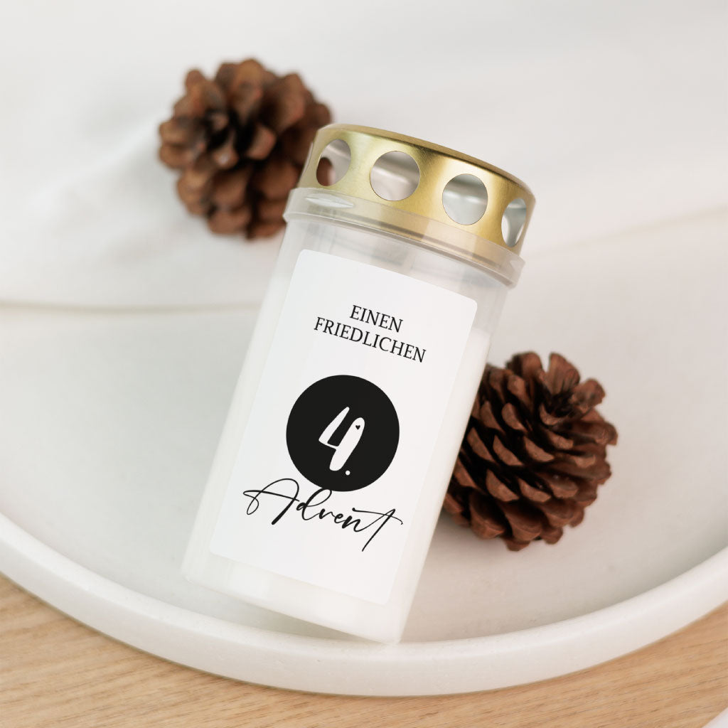 Einzeln dekorierte Grabkerze mit Aufkleber „4. Advent – einen friedlichen“, fotografiert mit Zapfendekoration – ideal als Erinnerung zu Weihnachten im Himmel.