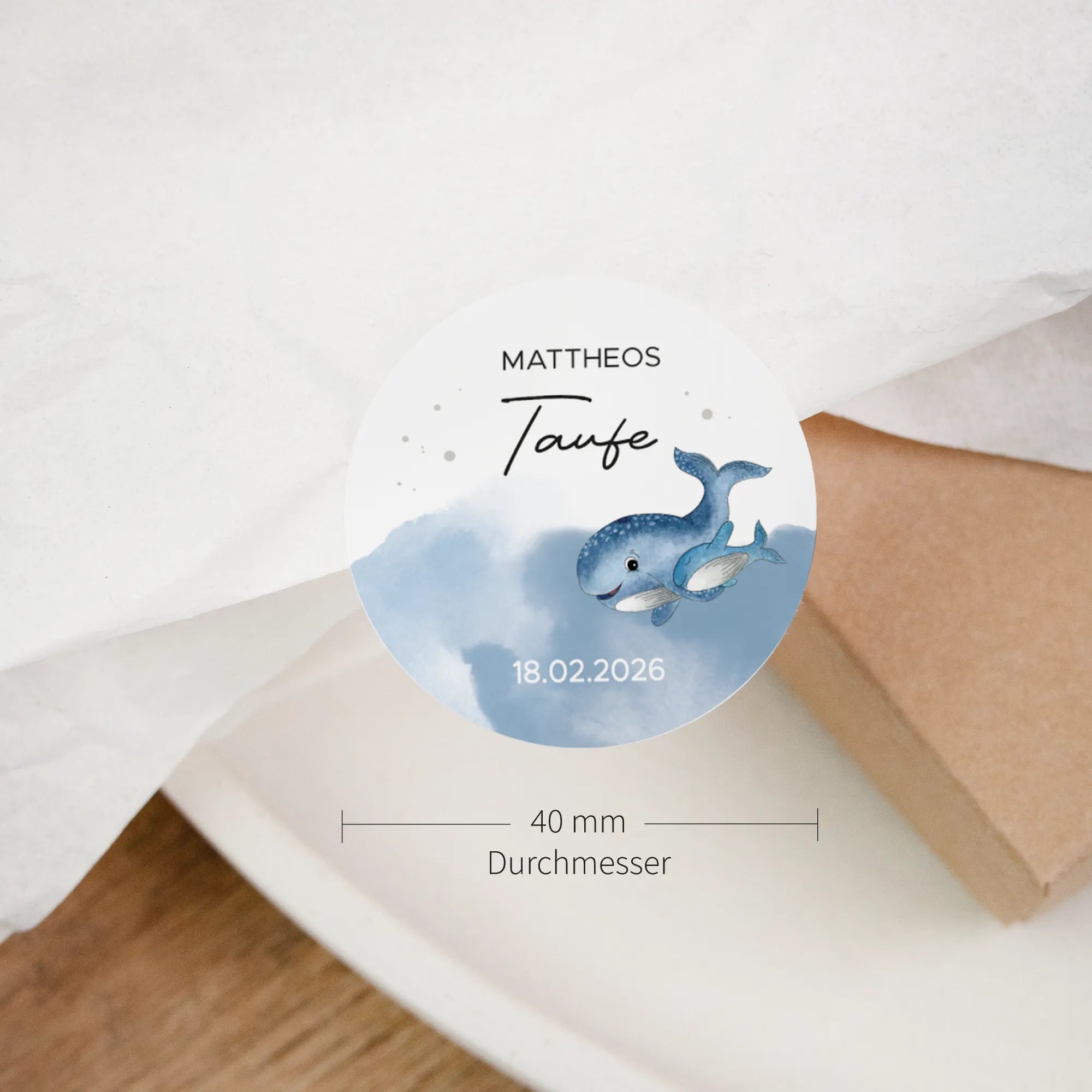 Nahaufnahme runder Taufe Aufkleber mit Aquarell Motiv blauem Wal, Schön dass du da bist, 40 mm Durchmesser auf Kraftpapier