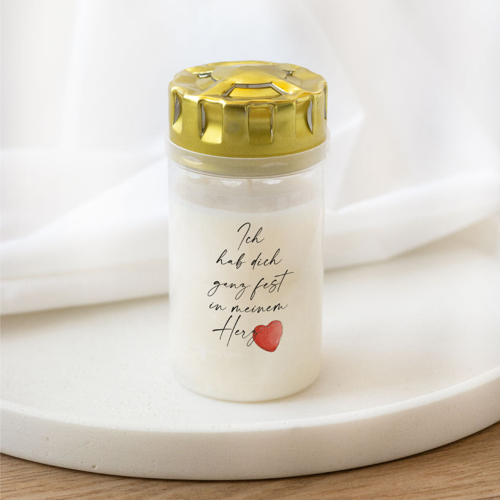 Grabkerze mit rundem Golddeckel und personalisiertem Aufkleber – transparenter Sticker mit rotem Aquarell-Herz, perfekt für ein persönliches Gedenken.