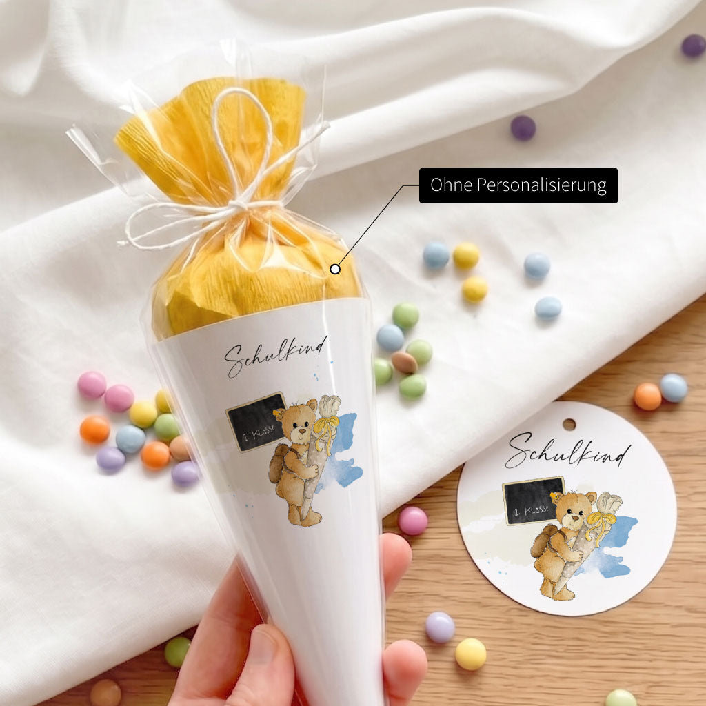 Mini Schultüte als DIY Bastelset ohne Personalisierung mit niedlichem Teddy Aquarell Motiv in der Hand gehalten.