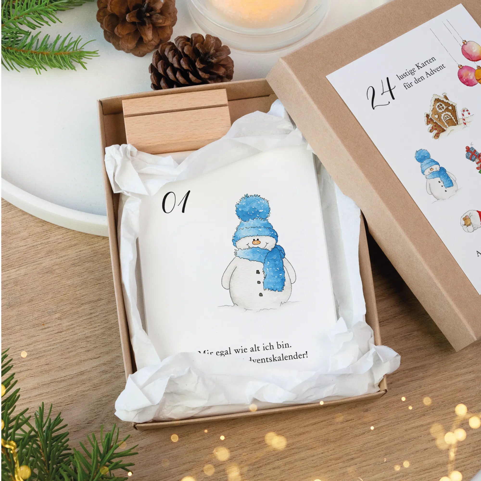 Adventskalender Karte 01 mit einem Schneemann Aquarell Motiv und witzigem Spruch in einer offenen Schachtel aus Kraftkarton.