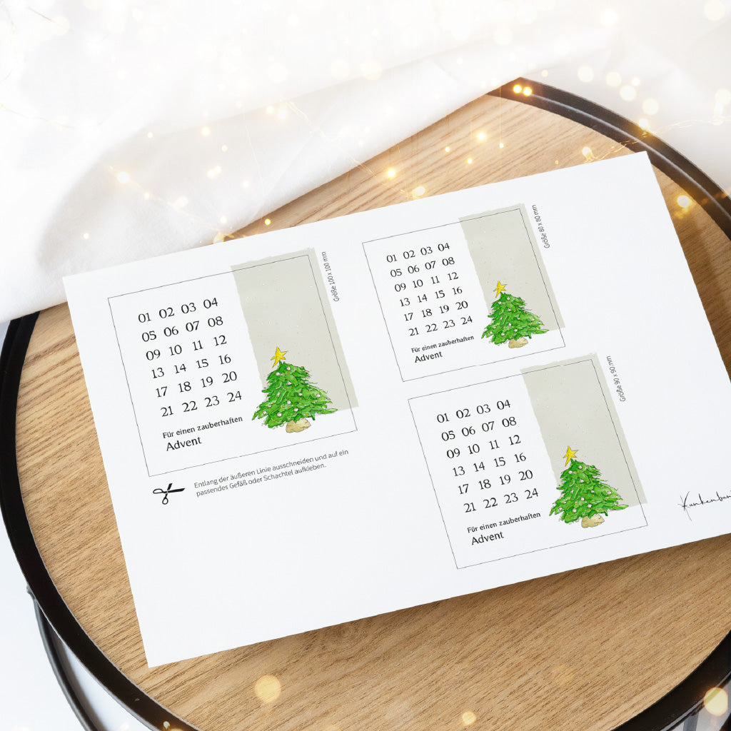Gedruckter DIN A4 Bogen auf einem Holztablett mit drei Größen vom Weihnachtsbaum Aquarell Motiv als PDF