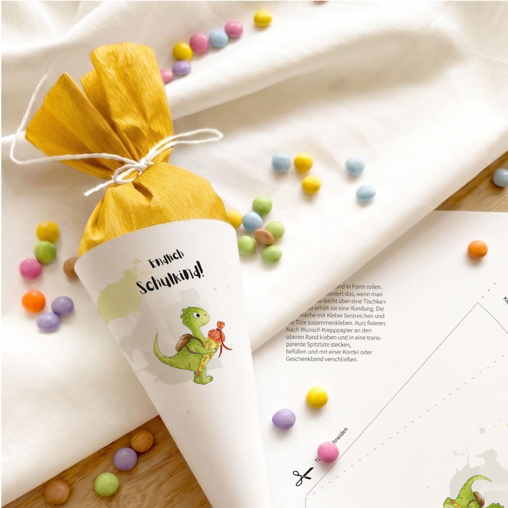 Fertig gebastelte Mini Schultüte mit Text Endlich Schulkind neben der ausgedruckten DIY Bastelvorlage.