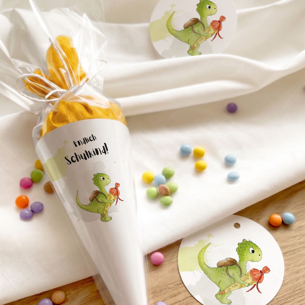 Dekoration zur Einschulung mit Mini Schultüte im Dino Design und runden Anhängern mit Dinosaurier Aquarell Motiv.