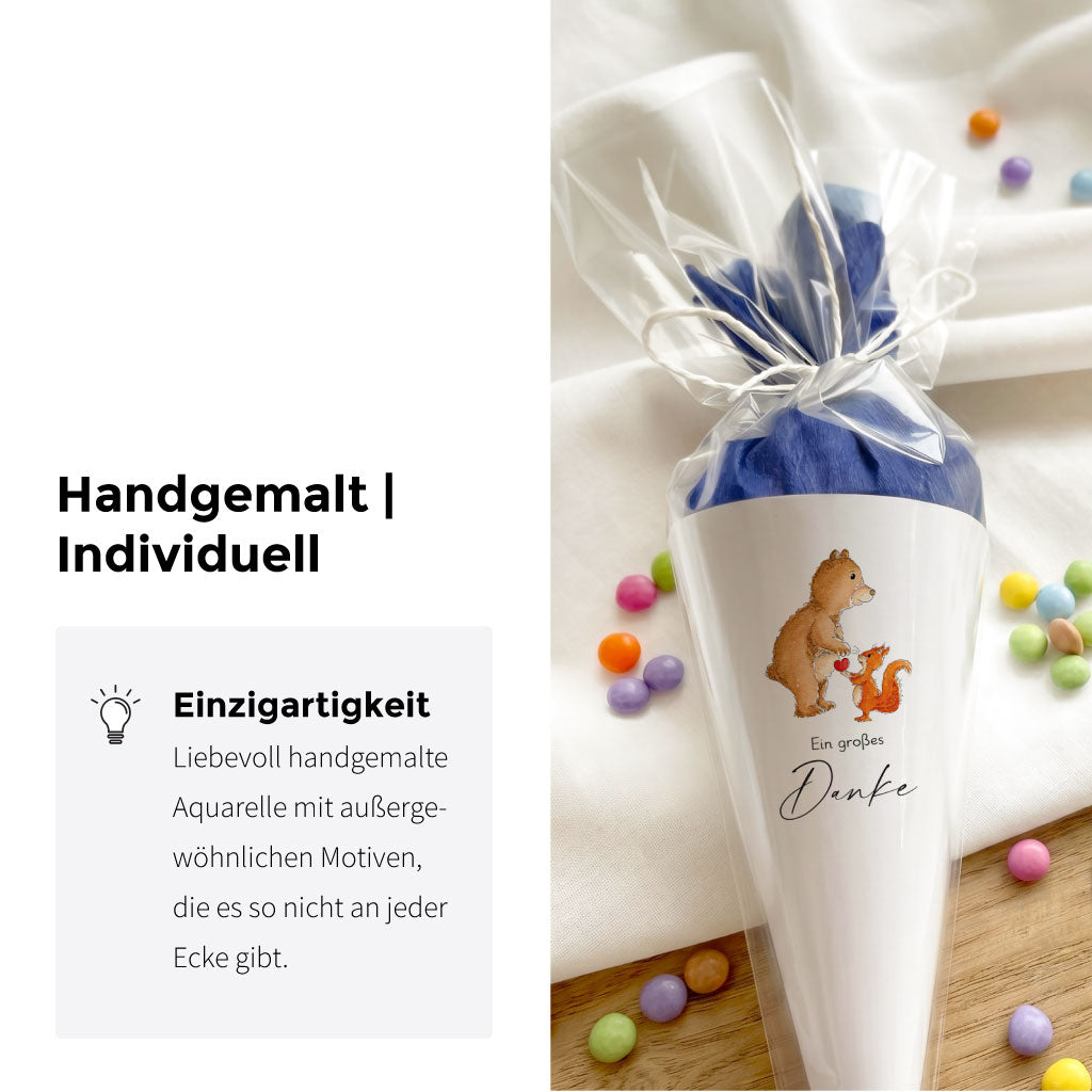 Nahaufnahme der gebastelten Schultüte mit handgemaltem Bär und Eichhörnchen Aquarell Motiv und blauem Krepppapier.