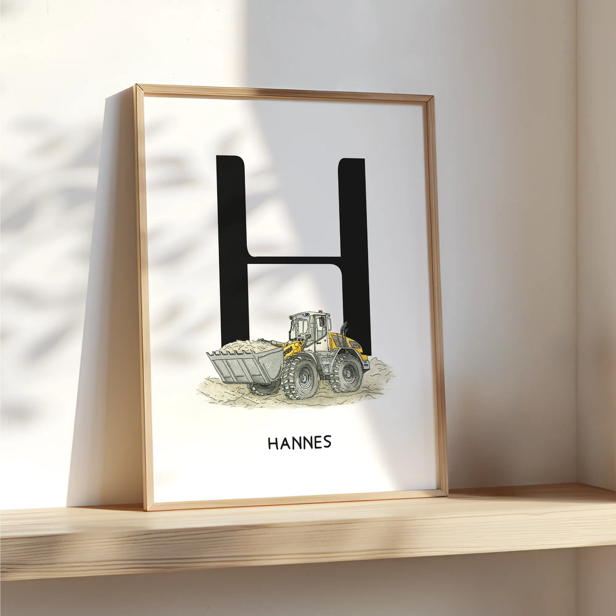 Personalisierbares Fahrzeugposter mit Aquarell Motiv Radlader, Initiale H und Name Hannes, im Holzrahmen auf einem Holzregal