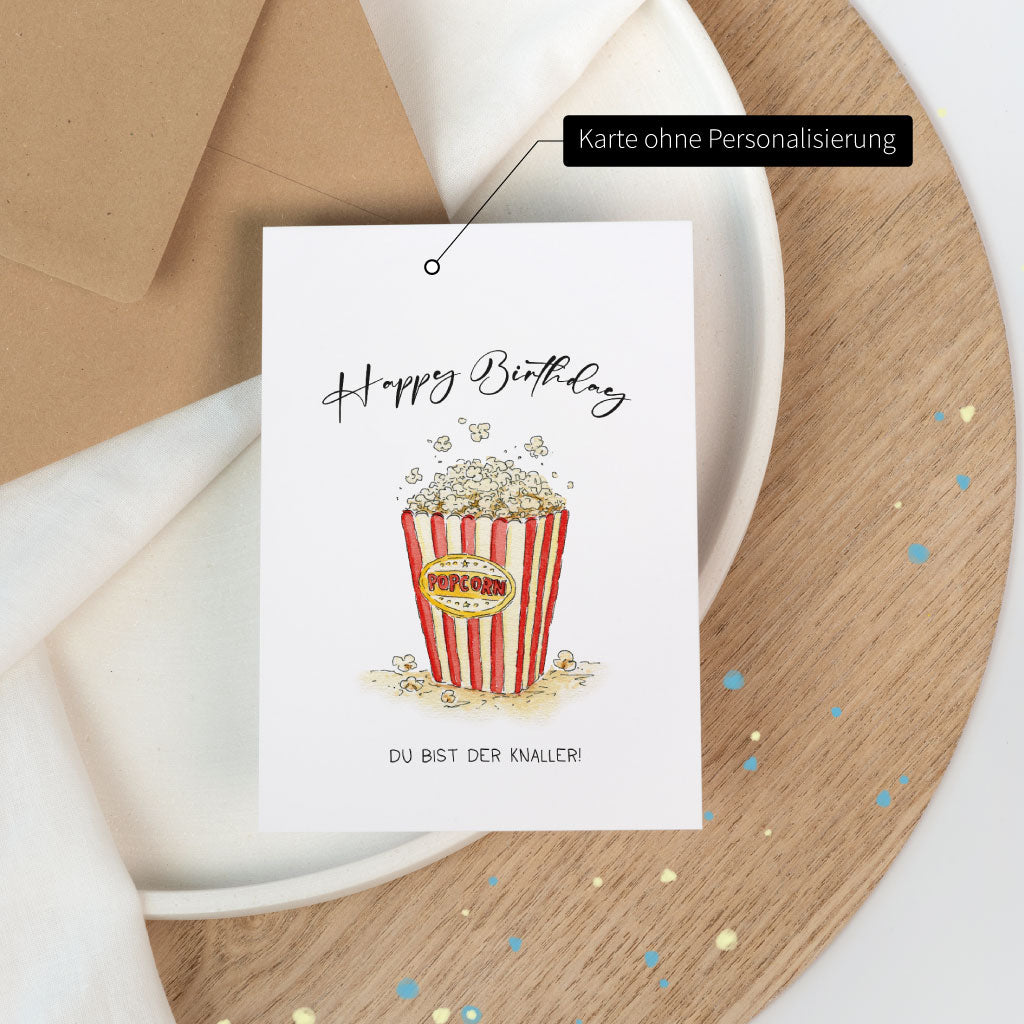 Nicht-personalisierte Variante der Popcorn-Geburtstagskarte mit Zirkusflair, liebevoll illustriert im Aquarellstil mit Spruch „Du bist der Knaller!“.
