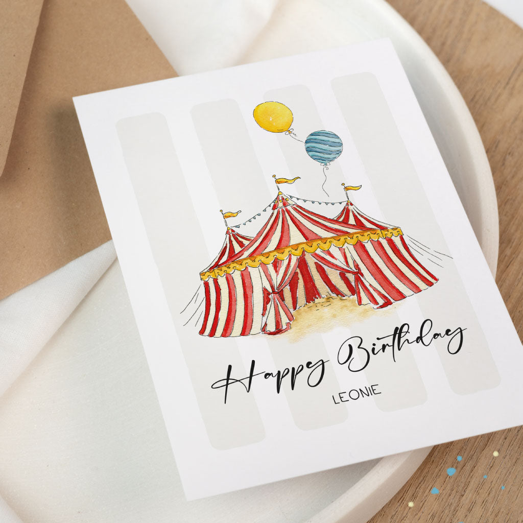 Zirkus-Geburtstagskarte im Aquarellstil mit roten und gelben Details, individualisierbar mit Name, auf hell-beigem Teller mit dezentem Konfetti-Hintergrund.