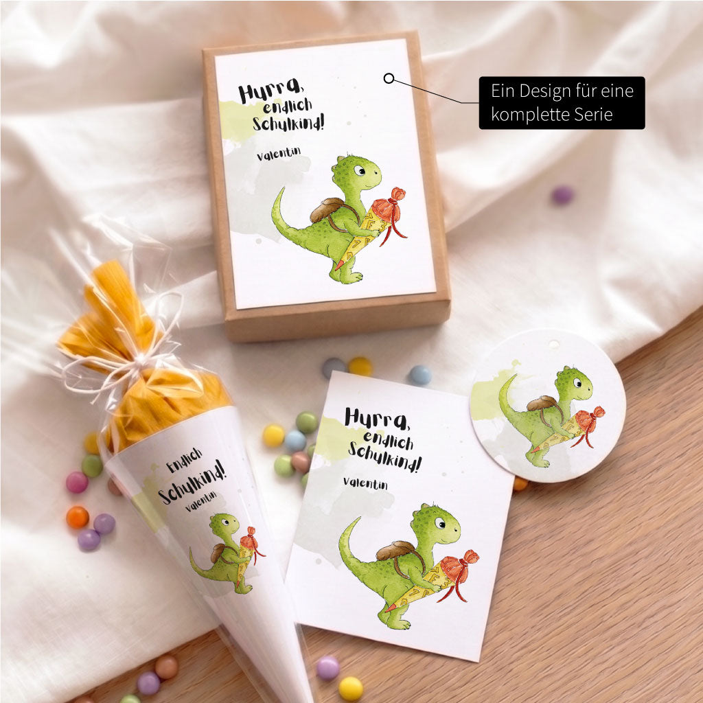 Set aus der Papeterie Serie zur Einschulung mit Geschenkbox, Karte, Anhänger und kleiner Schultüte mit Dino Motiv.