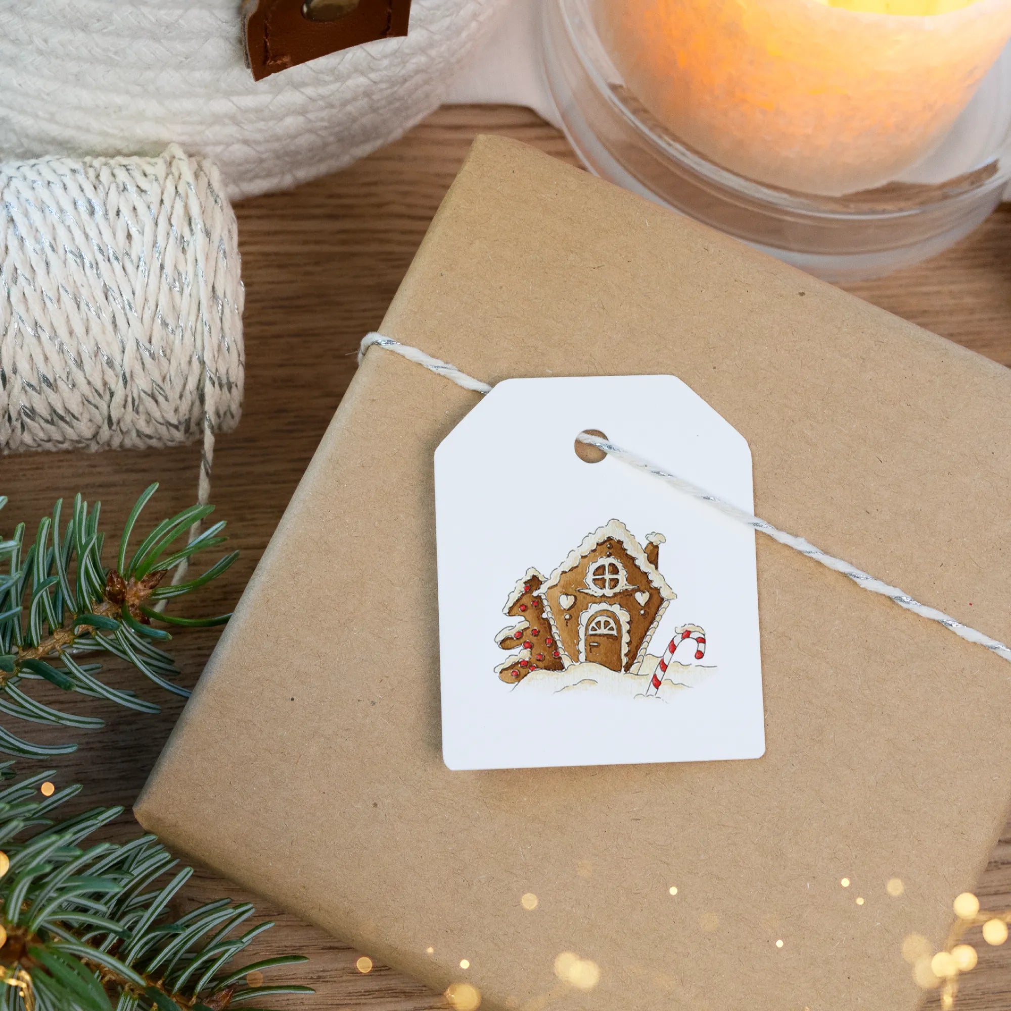 Süßes Lebkuchenhaus Aquarell Motiv auf einem weißen Anhänger für stimmungsvolle Weihnachtsgeschenke.