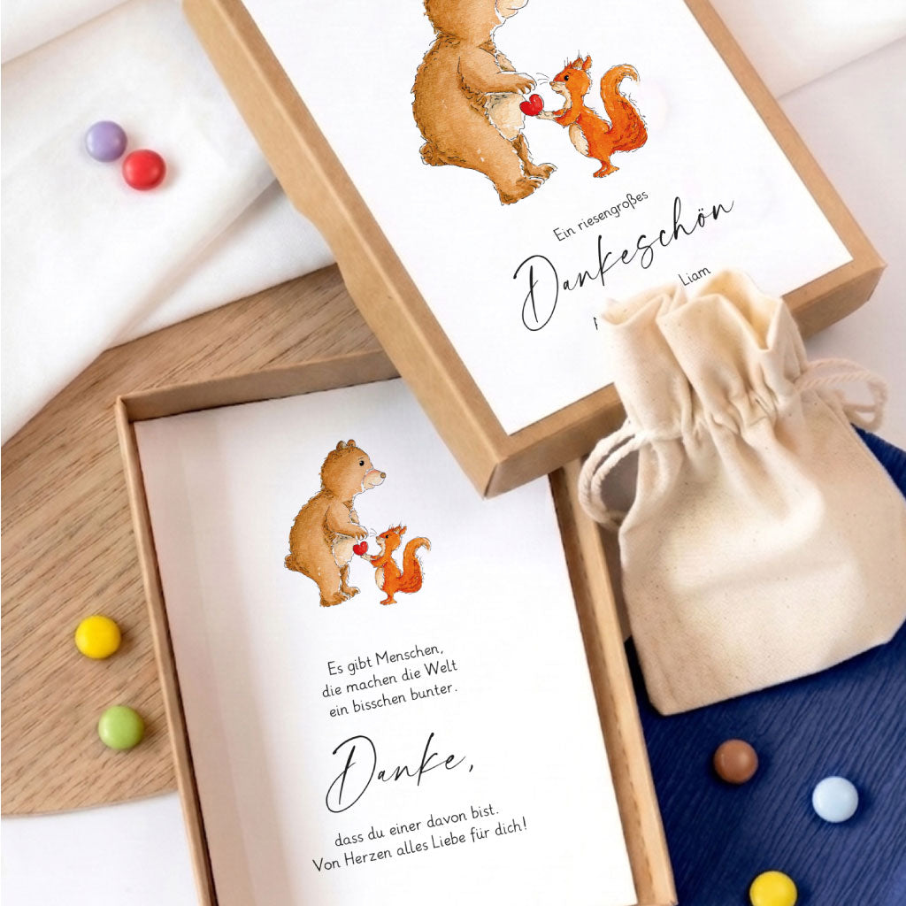 Geöffnete Geschenkschachtel zum Abschied von Kindergarten mit Dankeskarte und kleinem Geschenkbeutel aus Baumwolle.