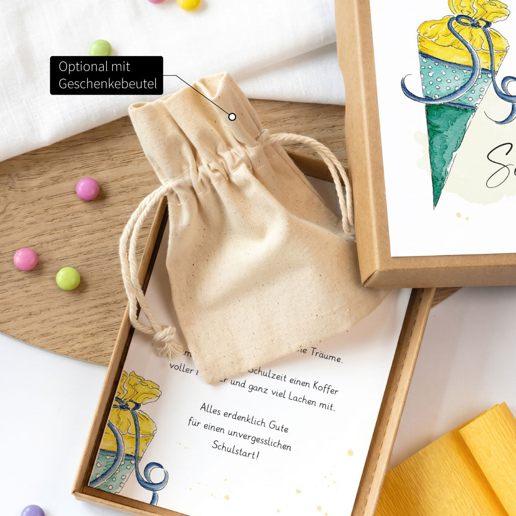 Geschenkbox zur Einschulung mit Wunschnamen personalisiert und einem bunten Schultüten Motiv dekoriert.