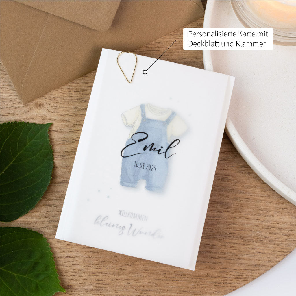 Babykarte zur Geburt mit liebevoll gemaltem Strampler in Blau, personalisierbar mit Name und Datum, edles Transparentpapier und goldene Klammer inklusive.