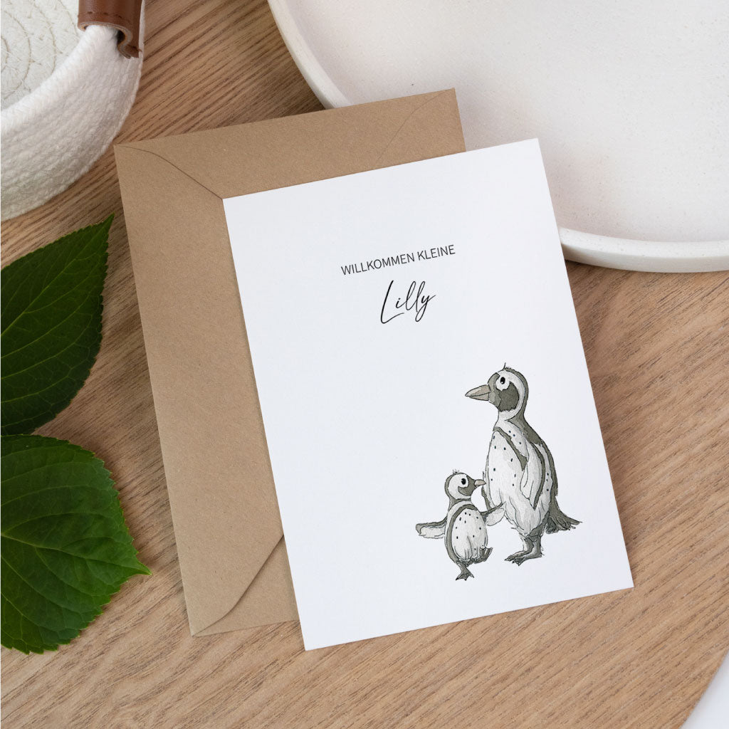 Personalisierbare Glückwunschkarte zur Geburt mit handgemaltem Aquarellmotiv von zwei Pinguinen und dem Text „Willkommen kleine Lilly“.