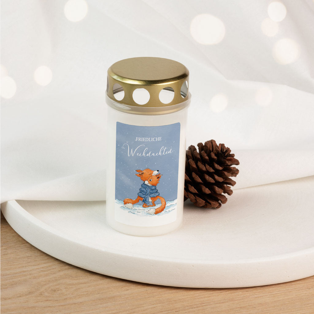 Weiße Grabkerze mit goldenem Deckel, handbemaltem Fuchs-Aufkleber und Schriftzug "Friedliche Weihnachten", dekoriert mit Tannenzapfen – ideales Grablicht für Weihnachten und Advent.
