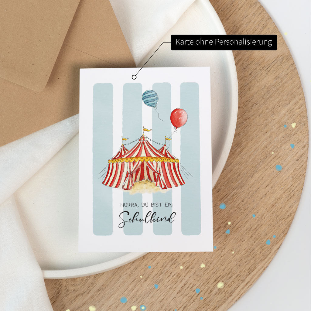 Karte ohne Personalisierung: Glückwunschkarte zur Einschulung mit Zirkus-Motiv, Schriftzug „Hurra, du bist ein Schulkind“ auf der Vorderseite.