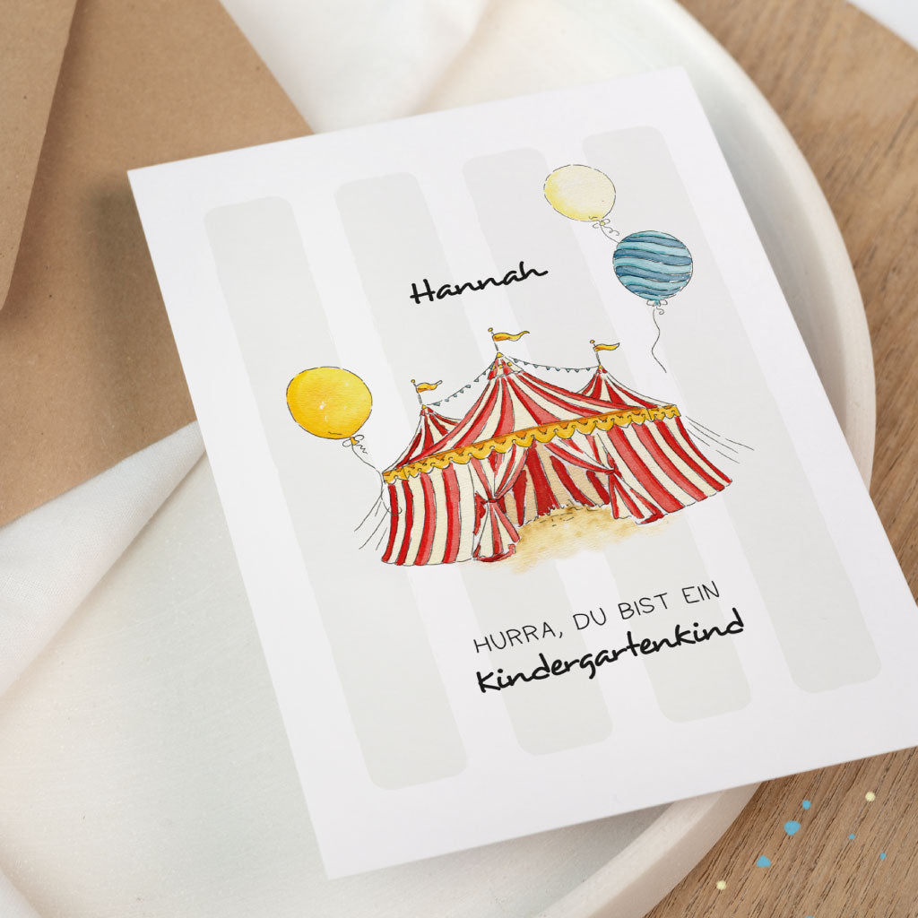 Detailfoto der Glückwunschkarte zum Kindergarten Beginn: Zirkus-Aquarellillustration mit rot-weißem Zelt, Ballons und persönlichem Namen