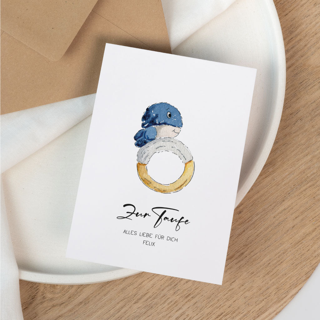 Personalisierbare Karte zur Taufe mit handgemaltem Wal und Schwimmring, dekoriert auf neutralem Hintergrund mit Umschlag