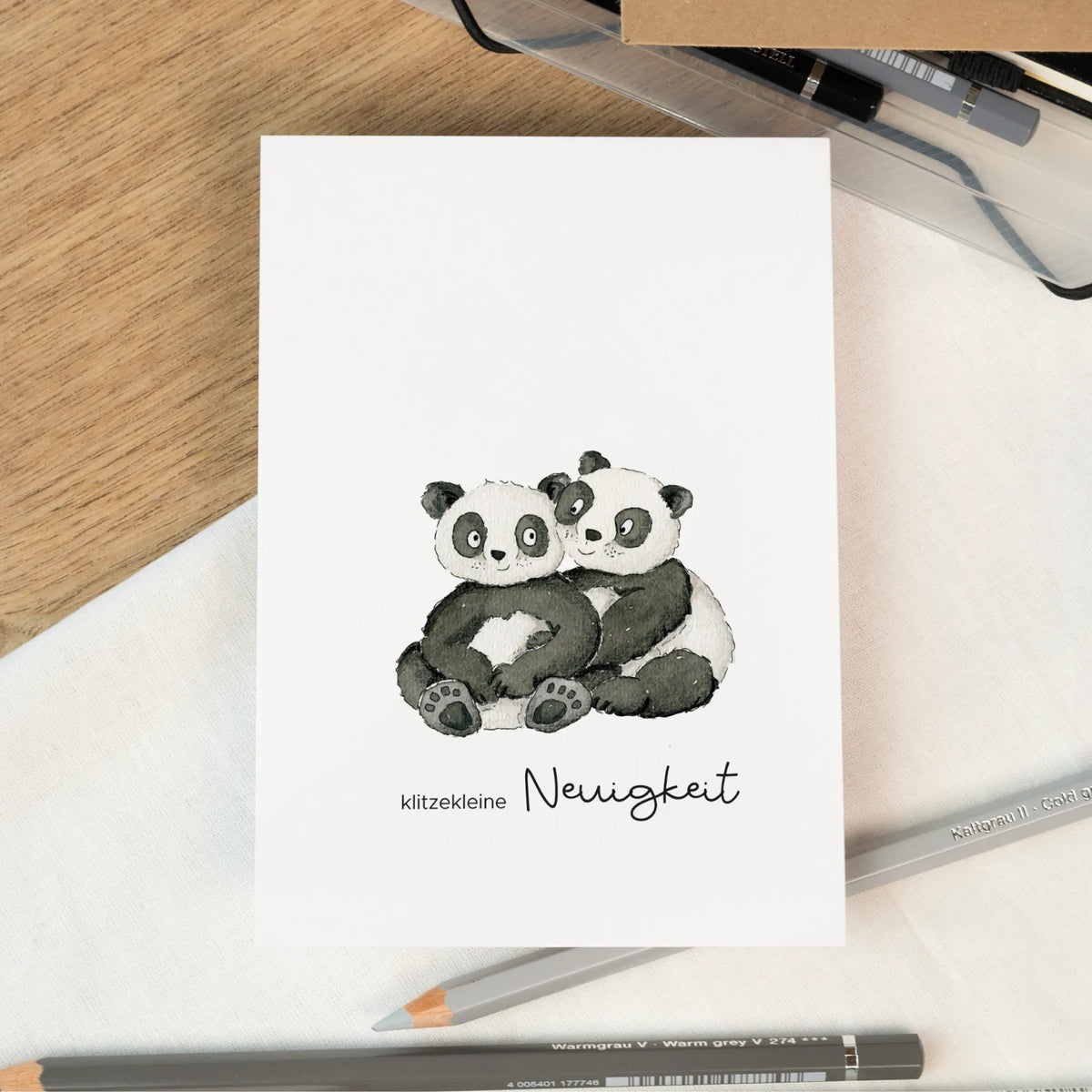 Karte zur Verkündung der Schwangerschaft mit zwei handgemalten Pandas und dem Text klitzekleine Neuigkeit
