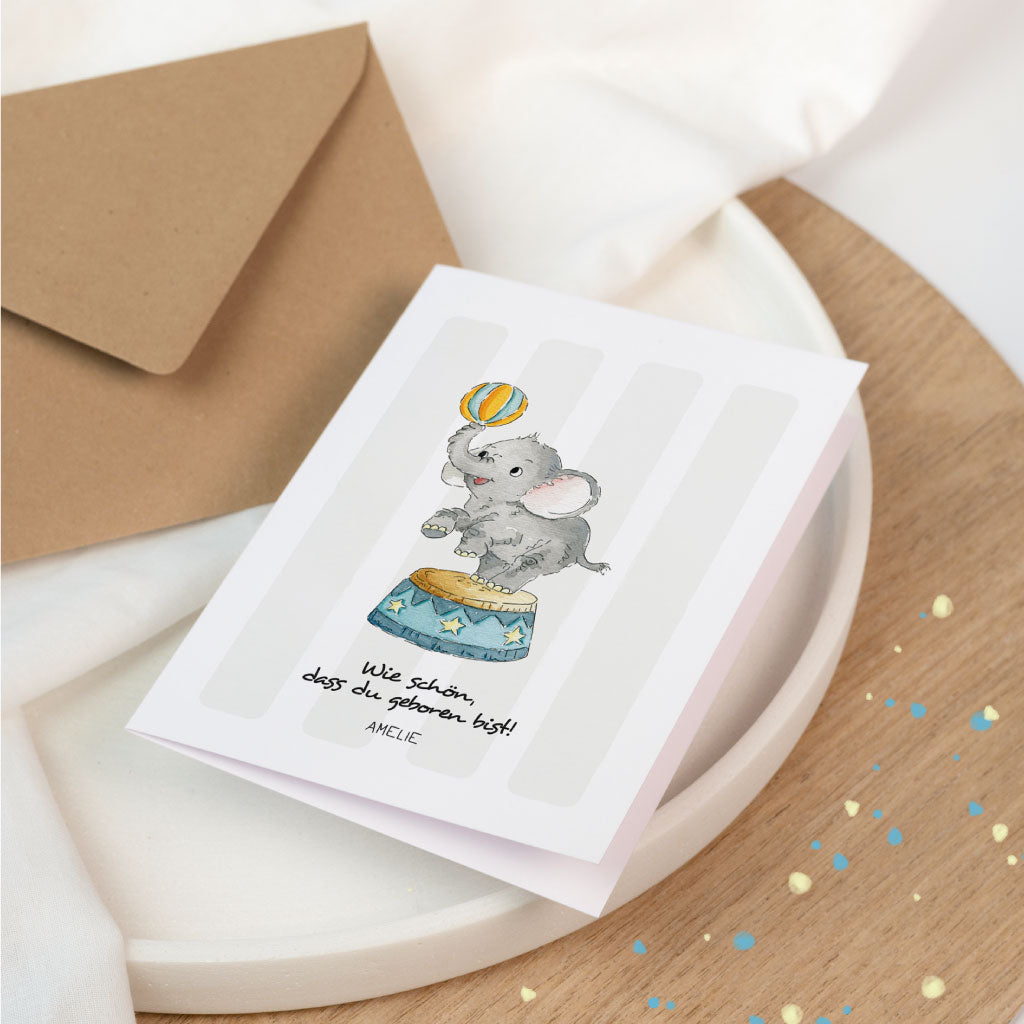 Personalisierbare Glückwunschkarte zur Geburt eines Babys mit Elefant im Zirkus-Motiv, handgemalt in Aquarell, Name „Amelie“ auf der Karte.