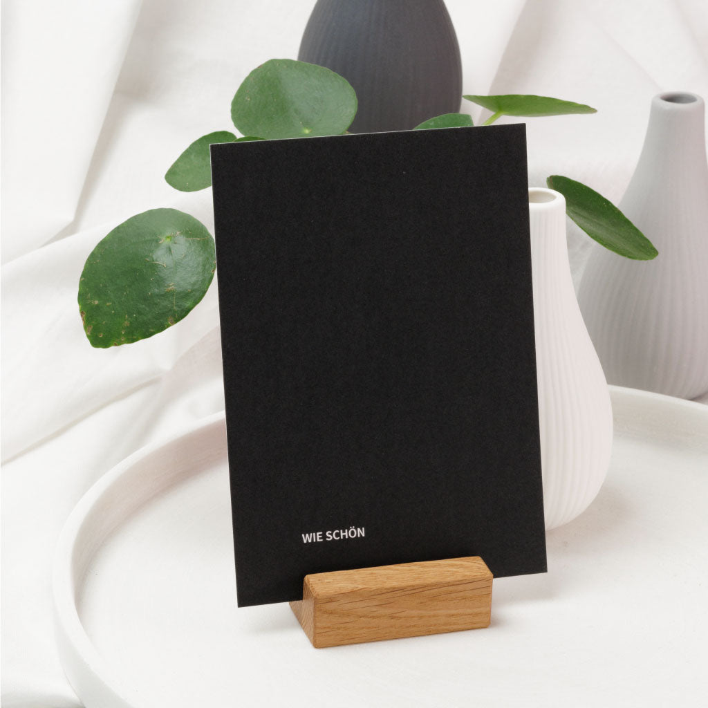 Schwarze Postkarte mit Aufdruck "Wie schön" in Kartenhalter aus Eichenholz