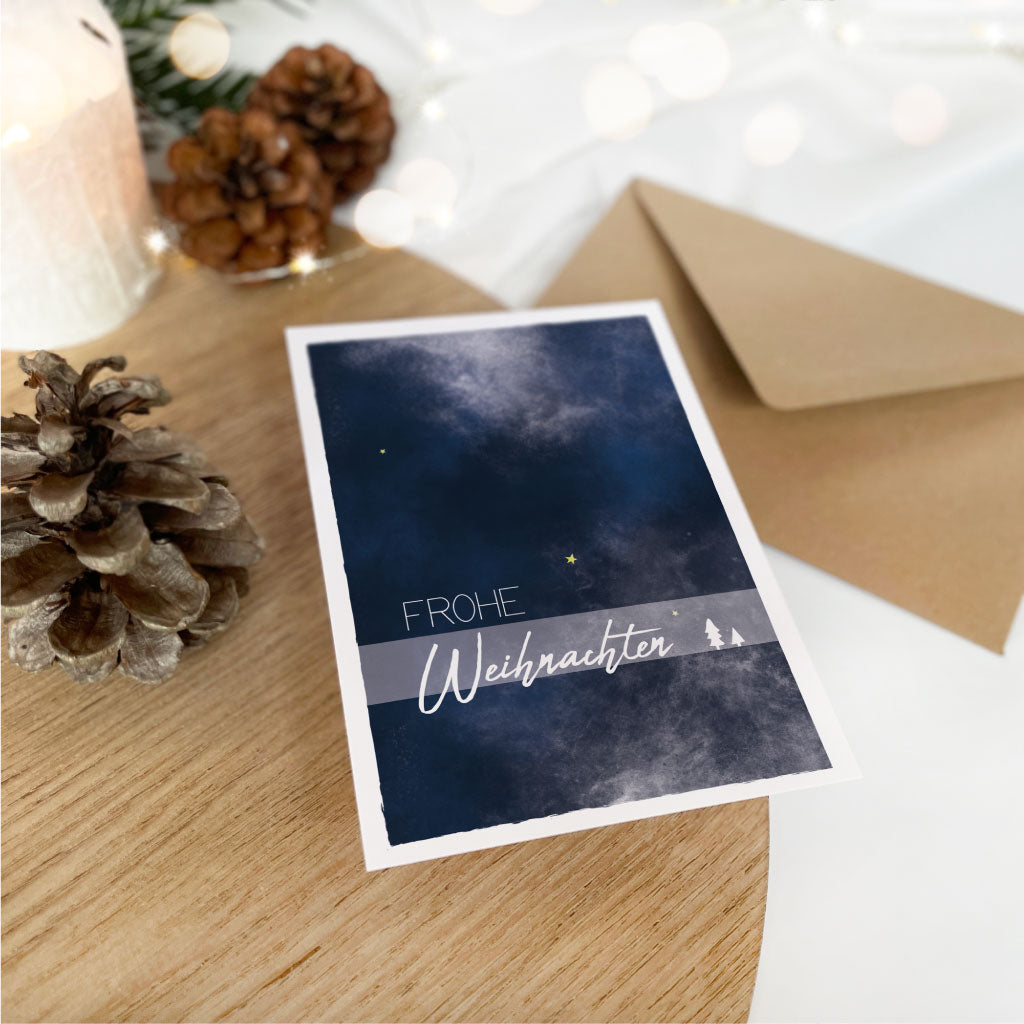 Weihnachtskarte "Frohe Weihnachten" mit Sternenhimmel im Winter und Tannenbäumchen