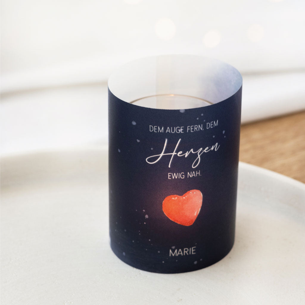 Teelichthülle mit rotem Herz und der Aufschrift „Dem Auge fern, dem Herzen ewig nah“ als stimmungsvolle Dekoration für Gedenkanlässe.