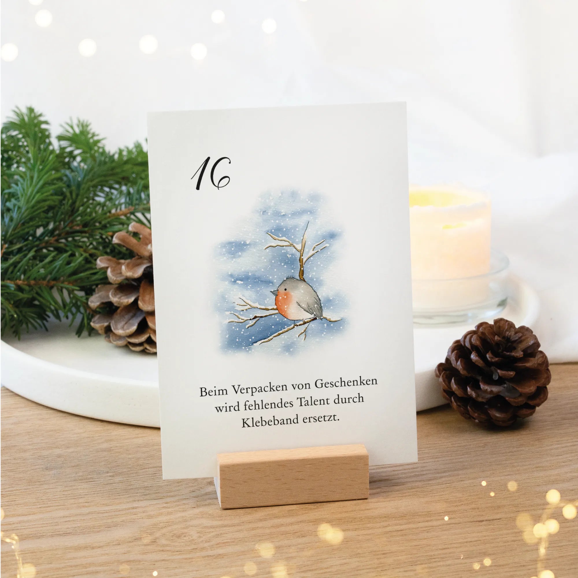 Adventskalender Karte 16 mit Rotkehlchen Aquarell Motiv im Buchenholz Kartenhalter auf Deko Teller.