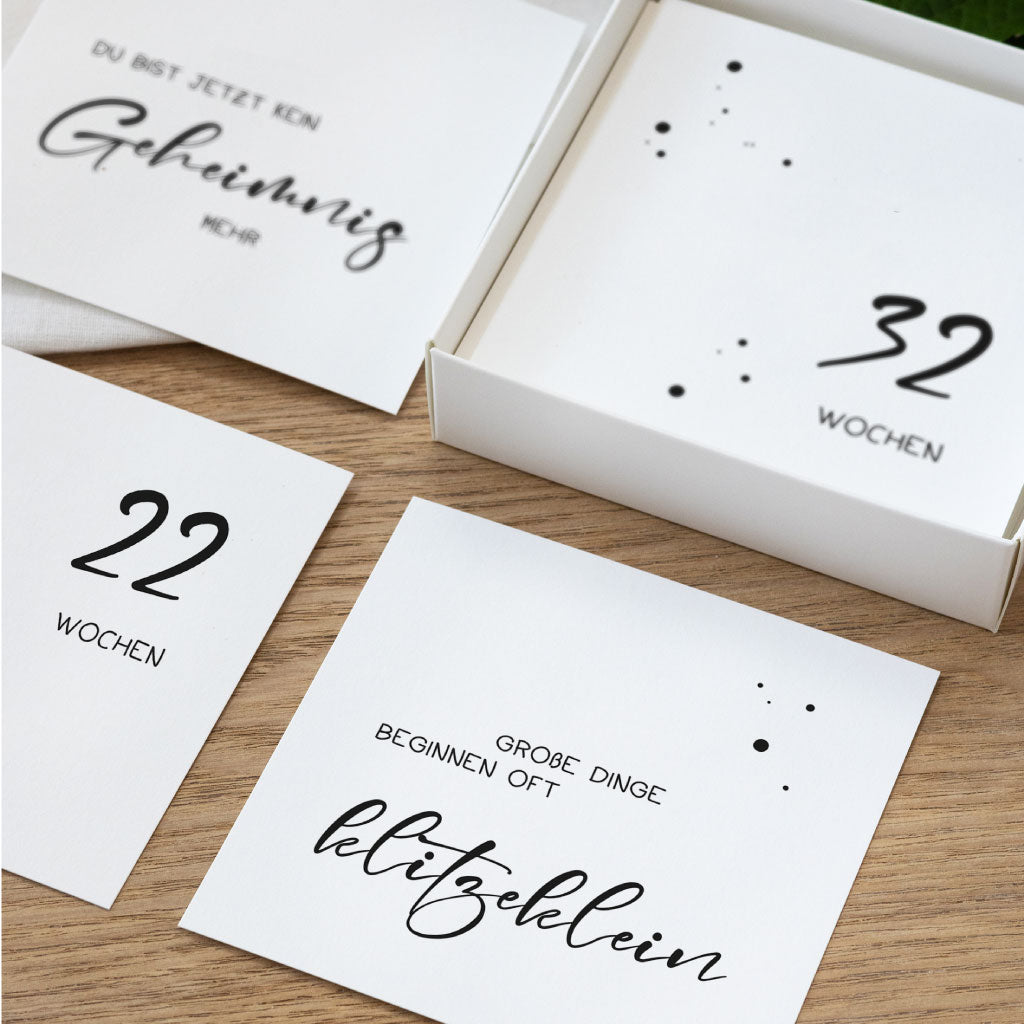 Detailaufnahme mehrerer Meilensteinkarten Schwangerschaft mit Wochenangaben und Sprüchen in moderner Typografie, liebevoll gestaltet im schlichten Design.