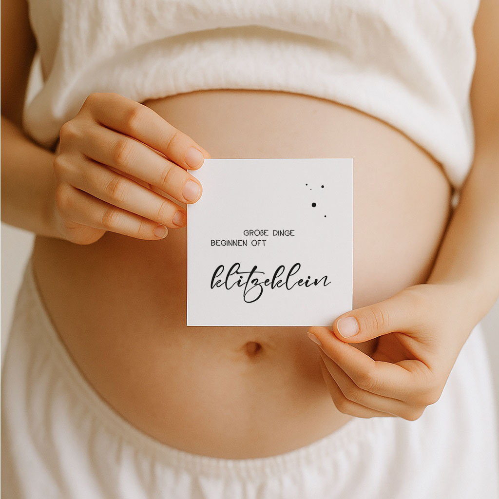 Schwangere Frau hält eine Meilensteinkarte mit Spruch vor ihren Bauch – emotionale Inszenierung der Schwangerschaftswochenkarten im natürlichen Setting.