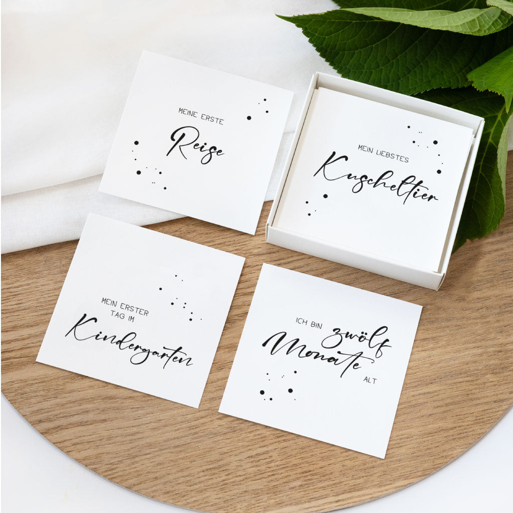 Setansicht mit Karten „Meine erste Reise“, „Mein liebstes Kuscheltier“, „Mein erster Tag im Kindergarten“ und „Ich bin zwölf Monate alt“ – Meilensteinkarten zum Fotos machen.