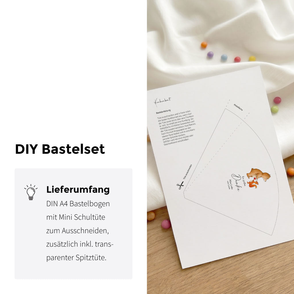 DIY Bastelset für Mini Schultüte mit Bär und Eichhörnchen Aquarell Motiv liegend auf Tisch neben bunten Schokolinsen.