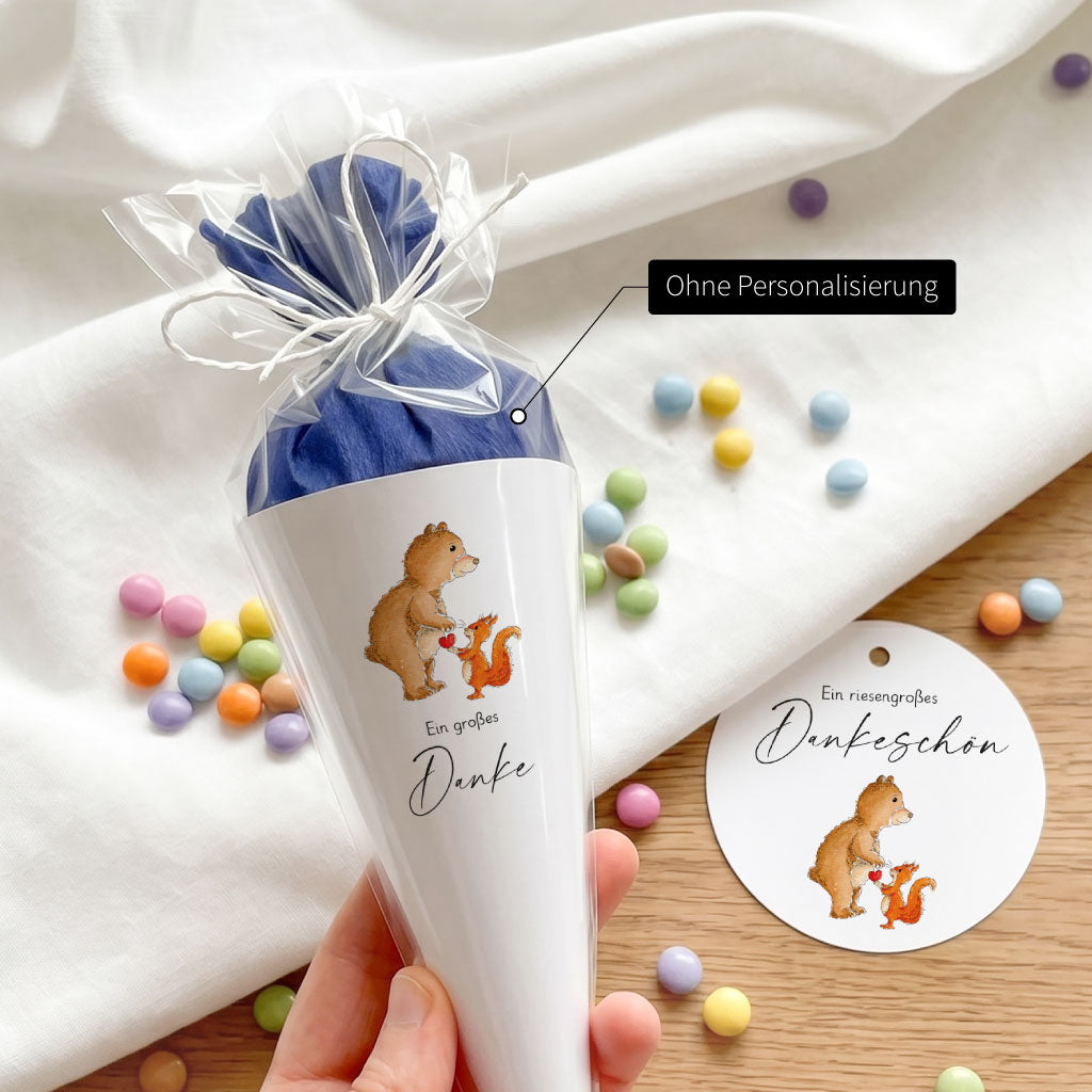 Hand hält fertige Mini Schultüte ohne Personalisierung mit unserem Bär und Eichhörnchen Aquarell Motiv zum Verschenken.