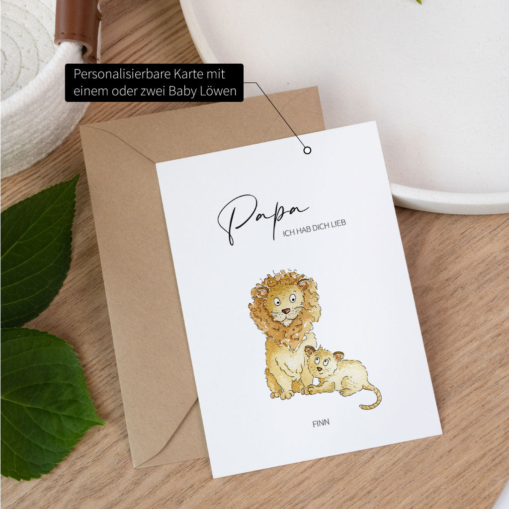 Personalisierbare Karte zum Vatertag mit einem handgemalten Löwen Aquarell Motiv und einem Baby Löwen auf einem Tisch.